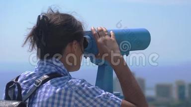 游客通过望远镜在索契。 年轻女子背着背包从高塔上望着望远镜